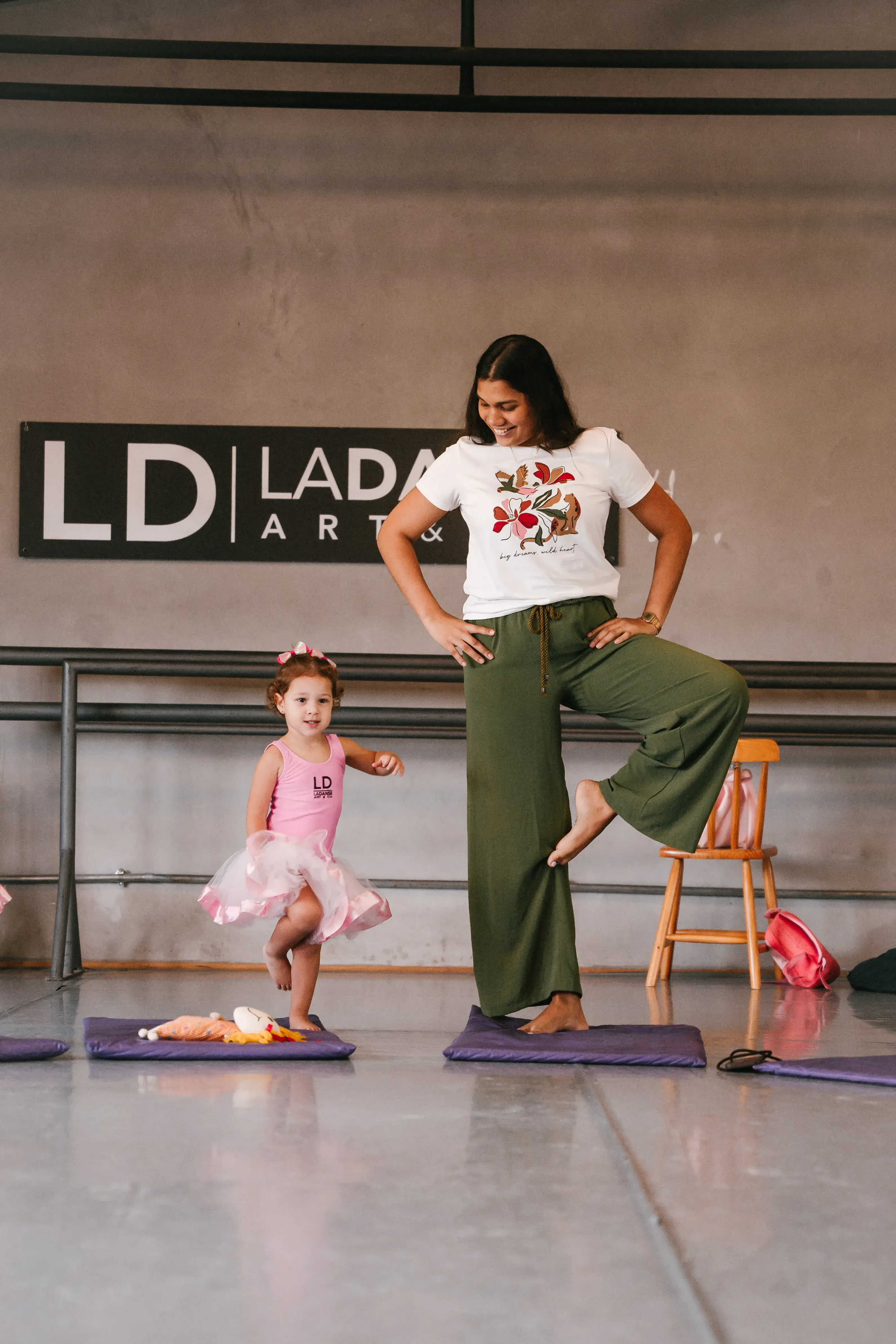 Professora orientando crianças em posições de ballet